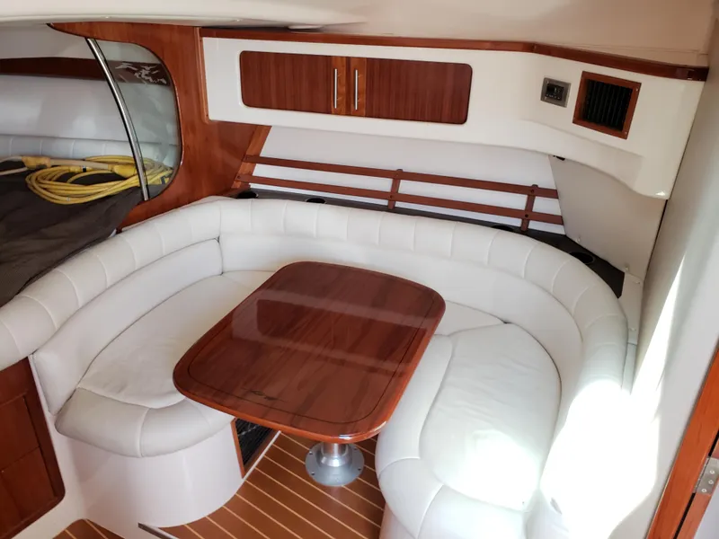 Slide: The Image of 2007 Grady-White Express 360 cabin with white leather seating and wooden table. - 8