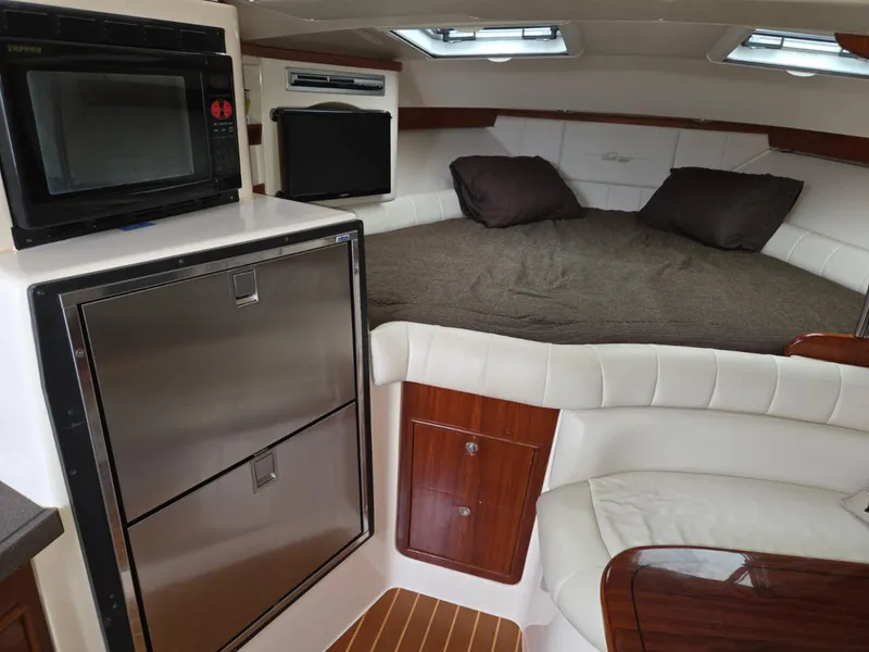 Slide: The Image of 2007 Grady-White Express 360 cabin interior with bed, microwave, and storage. - 9
