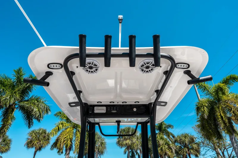 Slide: The Image of 2025 Sea Hunt Ultra 265 SE boat top view with rod holders and speakers, against a clear blue sky. - 20