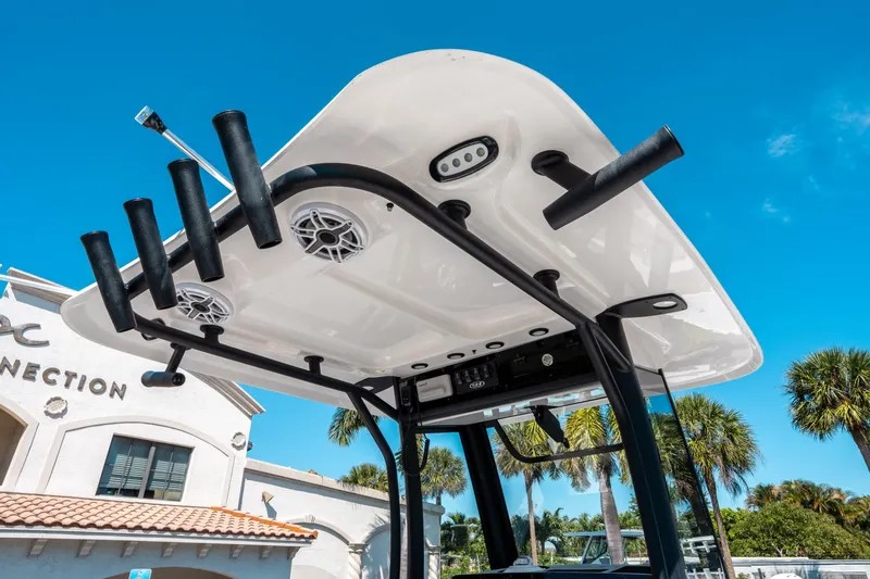 Slide: The Image of 2025 Sea Hunt Ultra 265 SE boat top with rod holders and speakers under clear blue sky. - 21