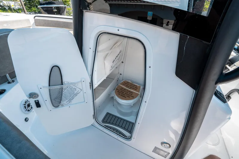Slide: The Image of 2025 Sea Hunt Ultra 265 SE boat interior with open restroom door. - 30