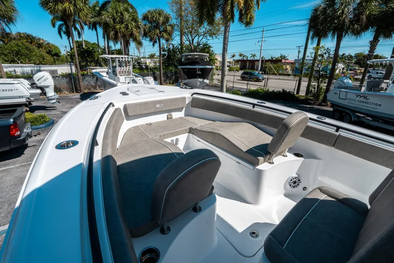 Slide: The Image of 2025 Sea Hunt Ultra 265 SE boat interior with cushioned seating and palm trees in the background. - 32