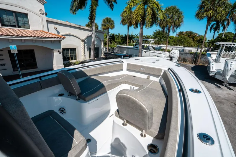 Slide: The Image of 2025 Sea Hunt Ultra 265 SE boat with spacious seating, parked outdoors under palm trees. - 33