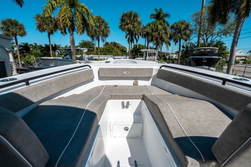 Slide: The Image of 2025 Sea Hunt Ultra 265 SE boat interior with cushioned seating, surrounded by palm trees. - 34