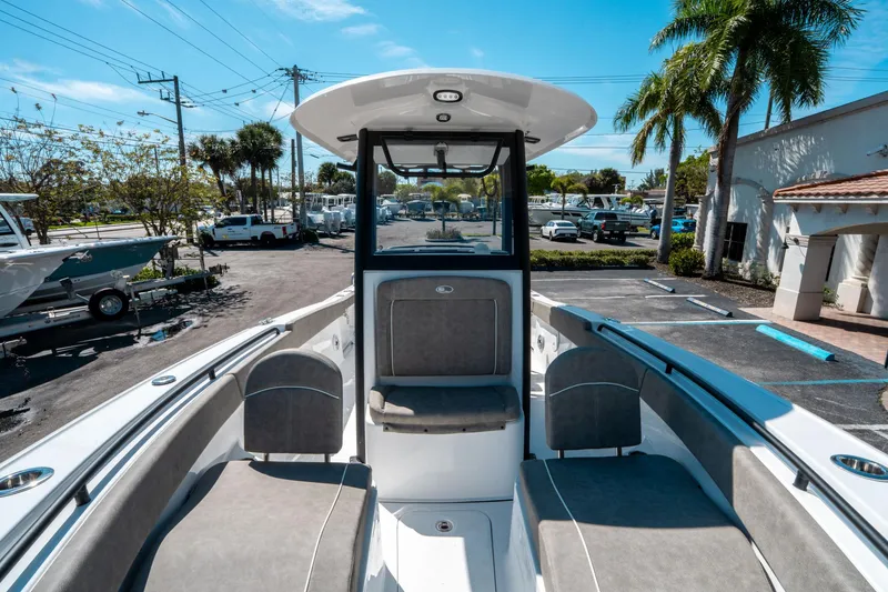 Slide: The Image of 2025 Sea Hunt Ultra 265 SE boat interior with seating, parked outdoors under clear sky. - 35