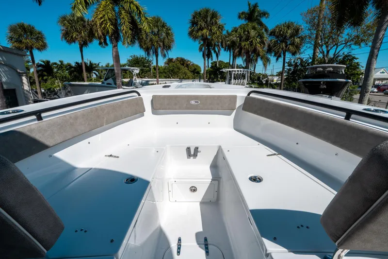 Slide: The Image of 2025 Sea Hunt Ultra 265 SE boat interior with seating, surrounded by palm trees. - 36