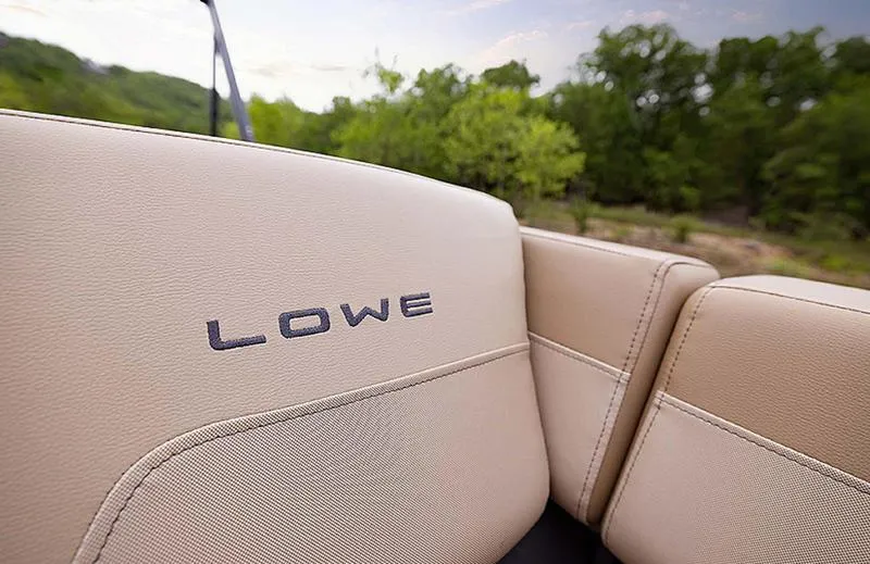 Slide: The Image of 2025 Lowe LS170 boat seat with logo, beige upholstery, outdoor setting. - 7