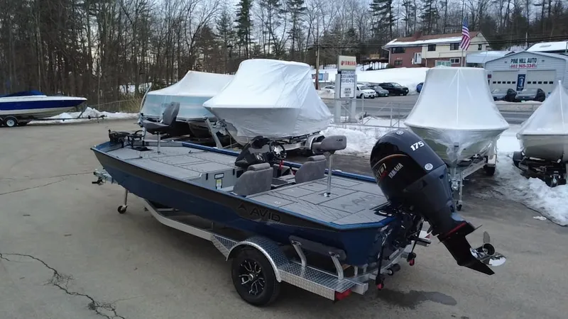 Slide: The Image of Avid 20 Vertex 2025 fishing boat with motor, parked outdoors in winter setting. - 7