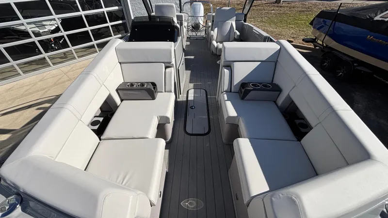 Slide: The Image of 2025 Balise HORIZON 24C boat interior with seating and canopy, parked outdoors. - 5