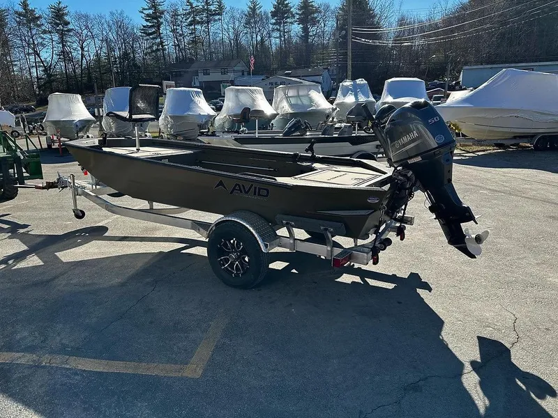 Slide: The Image of 2025 Avid 16 Commander boat on trailer, parked outdoors in a sunny area. - 6