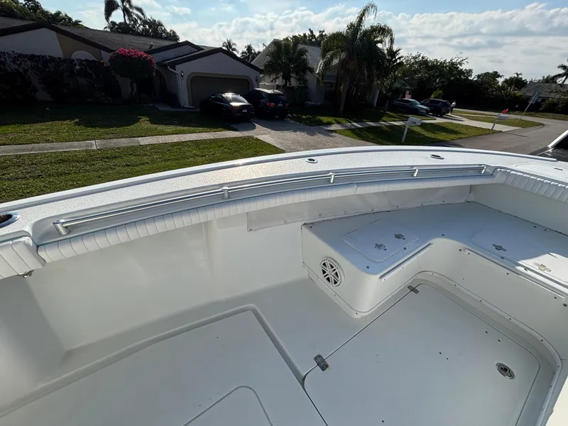 Slide: The Image of 2012 Yellowfin 29 boat deck with seating, parked in a residential neighborhood. - 18