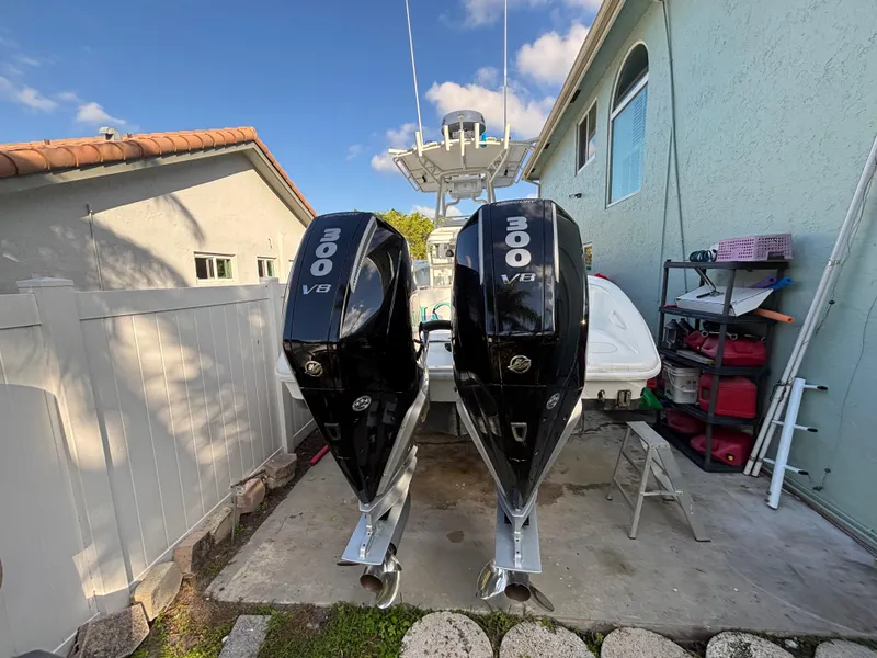 Slide: The Image of 2012 Yellowfin 29 boat with twin 300 V8 engines parked beside a house. - 4