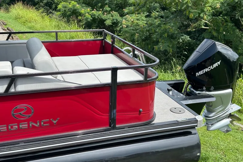 Slide: The Image of 2023 Regency 250DL3 pontoon boat with Mercury outboard motor, red exterior, and gray seating. - 6