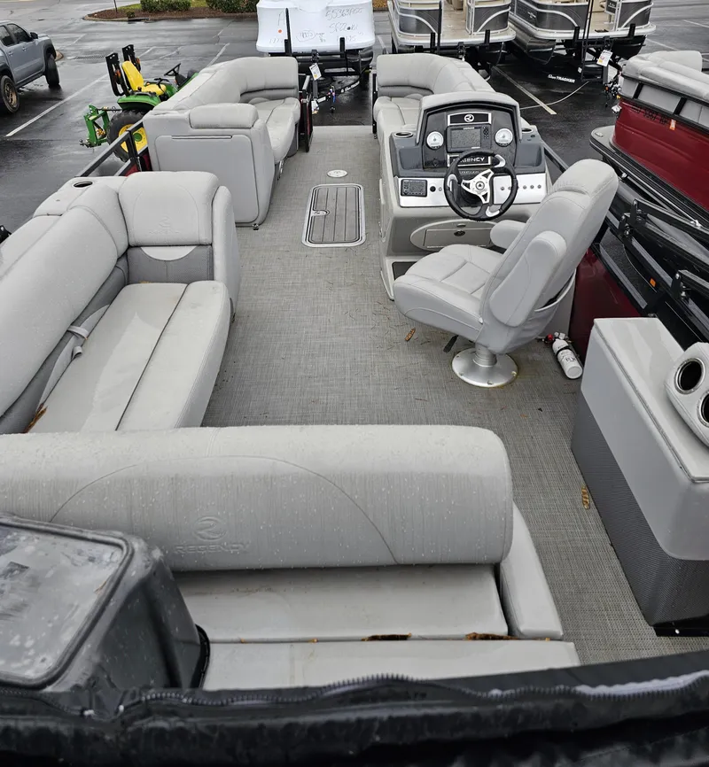 Slide: The Image of The image shows the interior of a 2023 Regency 250DL3 pontoon boat with gray seating and a helm. - 4