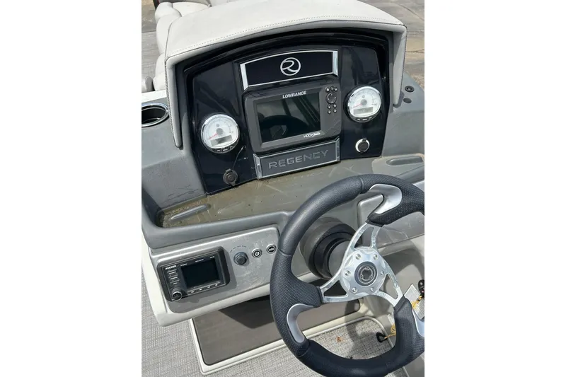 Slide: The Image of 2023 Regency 250DL3 boat dashboard with steering wheel and navigation controls. - 8