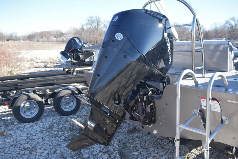 Slide: The Image of 2025 Lowe SD224 Sport Deck boat with powerful outboard motor on rocky terrain. - 5
