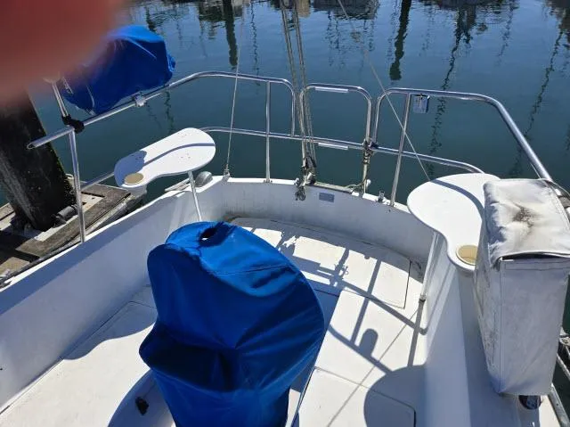 Slide: The Image of Cockpit of a 1983 Catalina 30 sailboat with blue covers and marina view. - 11