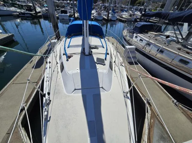 Slide: The Image of 1983 Catalina 30 sailboat docked in a marina, surrounded by other boats. - 15
