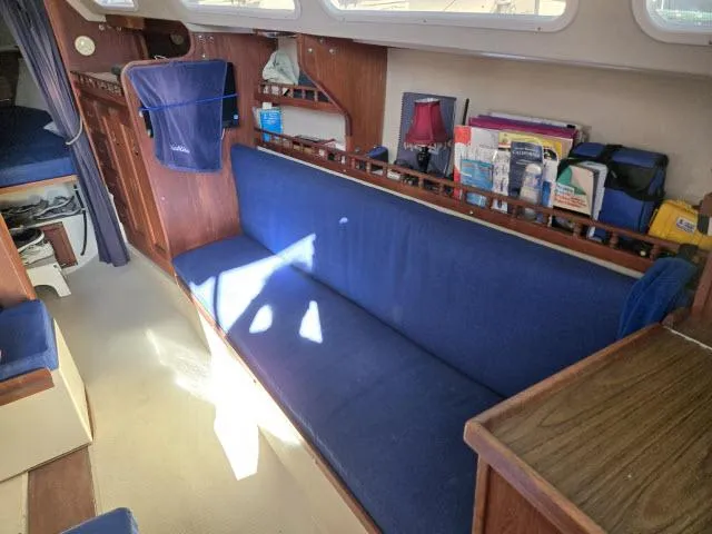 Slide: The Image of Interior of 1983 Catalina 30 sailboat with blue seating and wooden accents. - 3