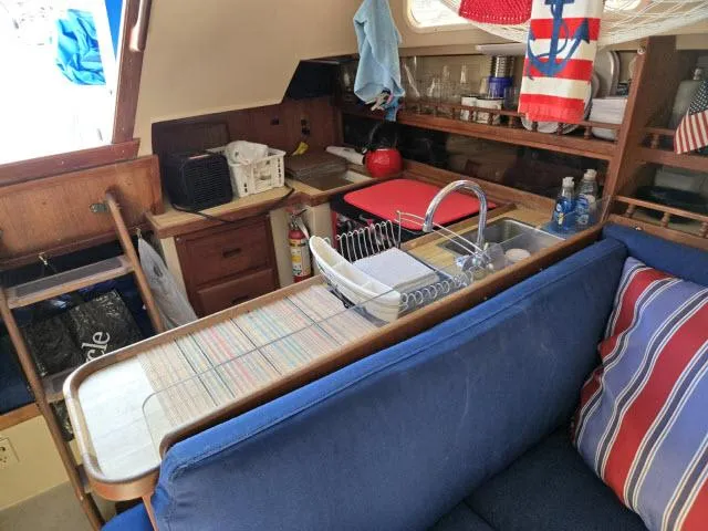 Slide: The Image of Interior of 1983 Catalina 30 sailboat with kitchen and seating area. - 5