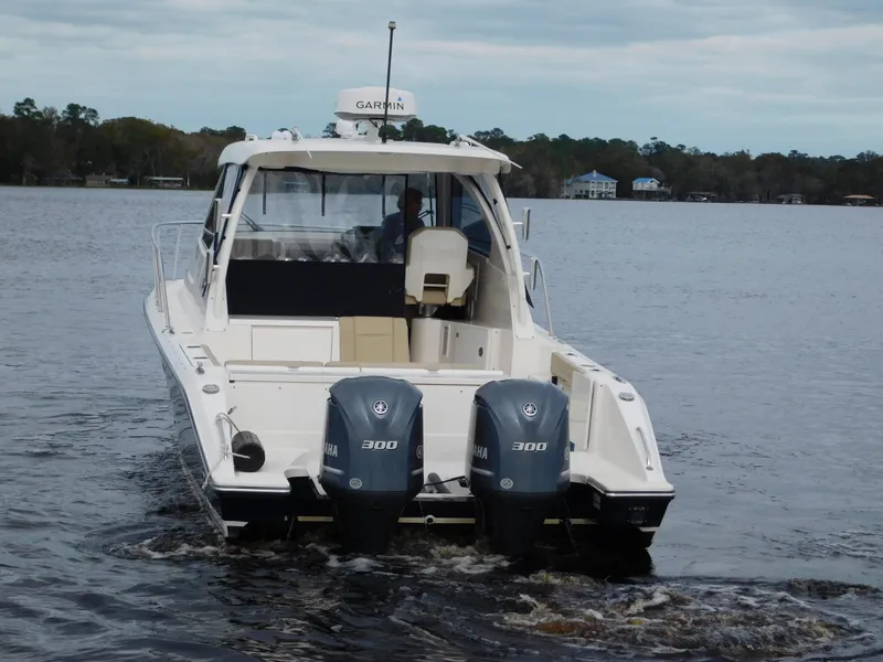 Slide: The Image of 2018 Pursuit OS 325 Offshore boat with dual Yamaha 300 engines on a calm lake. - 10