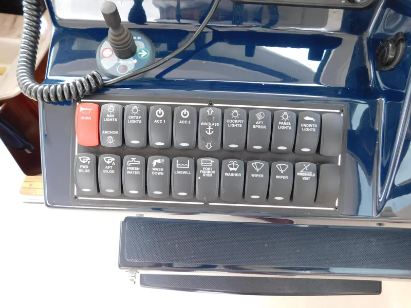 Slide: The Image of Control panel of 2018 Pursuit OS 325 Offshore boat with labeled switches and joystick. - 21