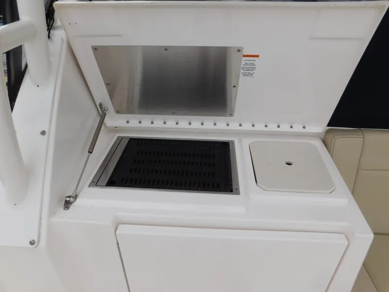 Slide: The Image of 2018 Pursuit OS 325 Offshore boat grill and storage compartment. - 28