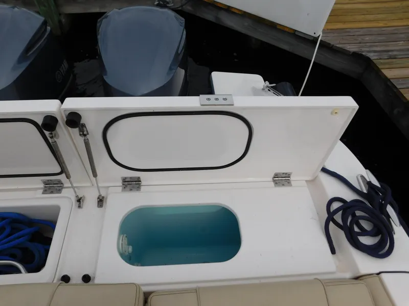 Slide: The Image of Open storage compartment on 2018 Pursuit OS 325 Offshore boat with visible ropes and equipment. - 38