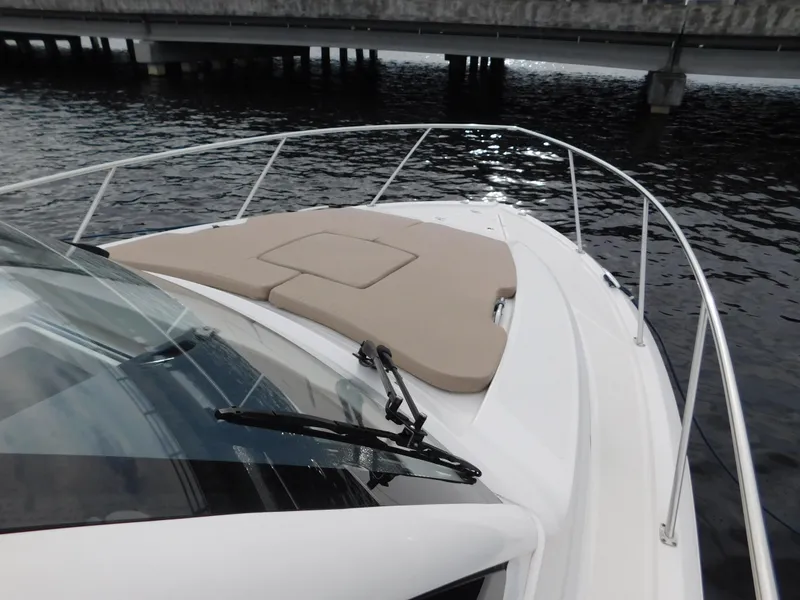Slide: The Image of 2018 Pursuit OS 325 Offshore boat with cushioned deck, docked near a bridge. - 46