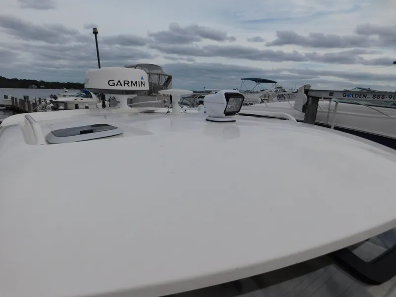 Slide: The Image of 2018 Pursuit OS 325 Offshore boat with Garmin equipment on deck, docked under cloudy skies. - 47