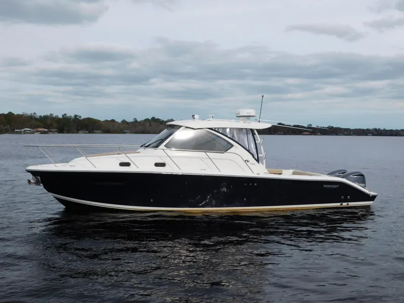 Slide: The Image of 2018 Pursuit OS 325 Offshore boat on calm water under cloudy sky. - 8