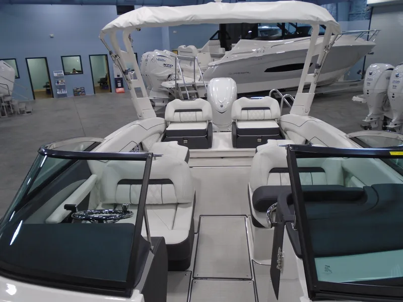 Slide: The Image of 2025 Regal LX6 boat interior with white seating and modern design in showroom. - 30