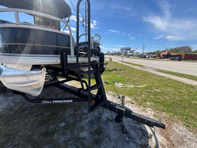 Slide: The Image of 2020 Sun Tracker Bass Buggy 18 DLX on trailer, parked roadside under clear sky. - 25