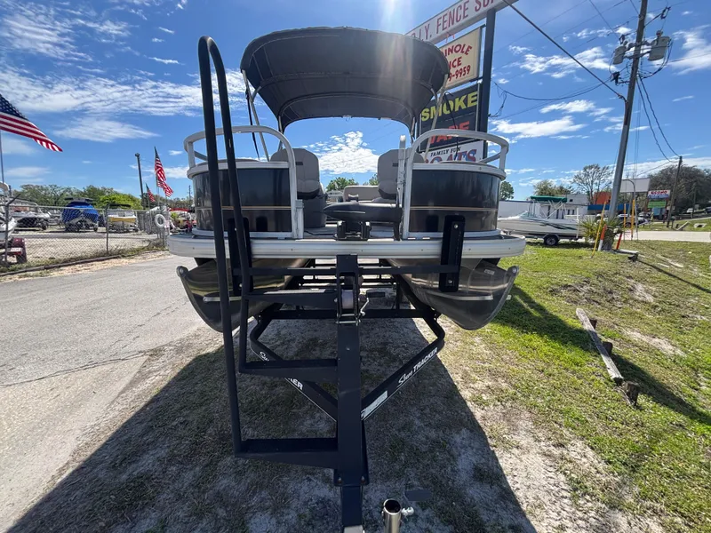 Slide: The Image of 2020 Sun Tracker Bass Buggy 18 DLX pontoon boat on trailer, parked outdoors. - 26