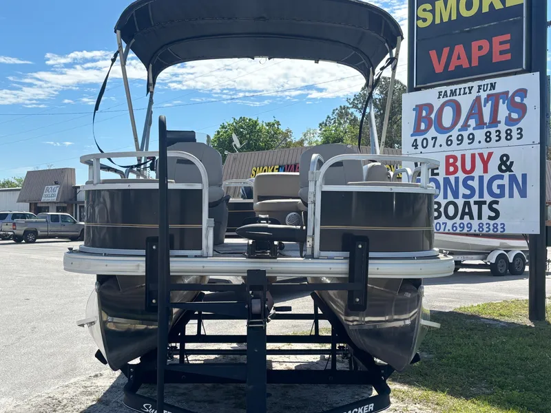 Slide: The Image of 2020 Sun Tracker Bass Buggy 18 DLX pontoon boat displayed at a dealership. - 4