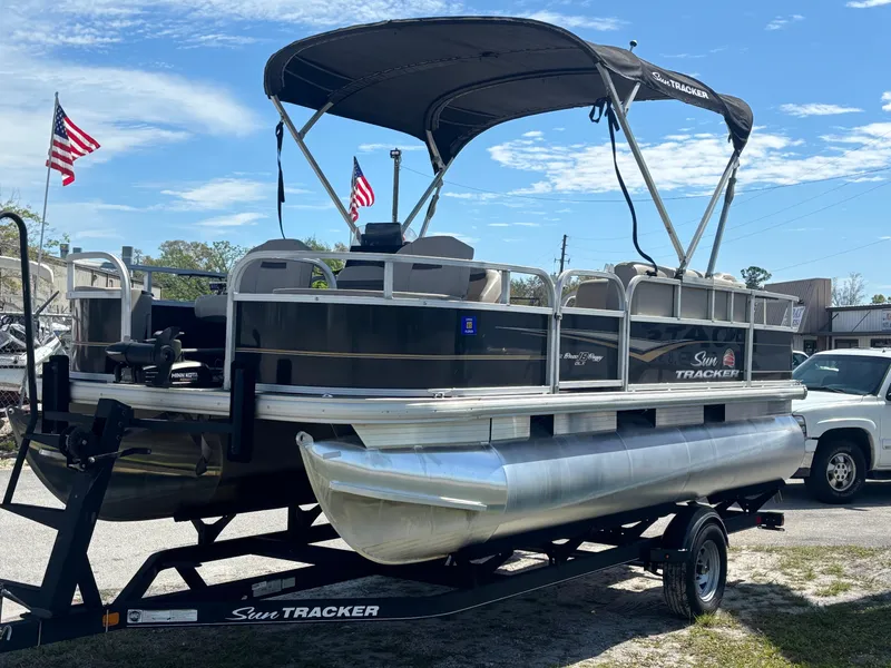 Slide: The Image of 2020 Sun Tracker Bass Buggy 18 DLX pontoon boat on trailer, with canopy and American flags. - 5