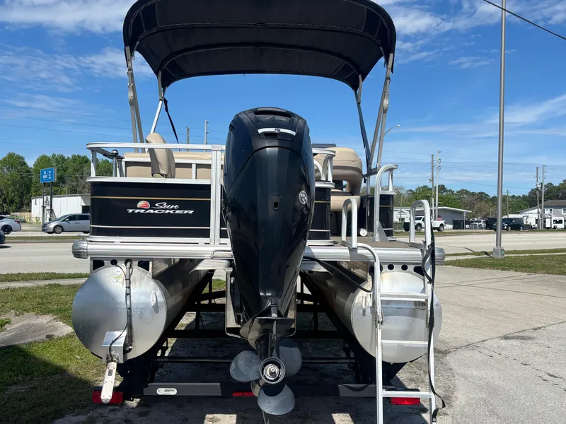 Slide: The Image of 2020 Sun Tracker Bass Buggy 18 DLX pontoon boat with outboard motor, parked outdoors. - 7