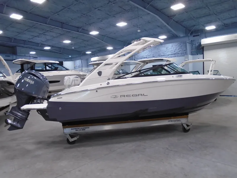 The Image of 2025 Regal LX2 boat in showroom, featuring sleek design and Yamaha outboard motor. - 1