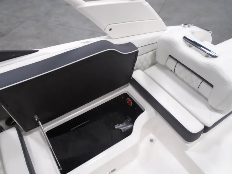 Slide: The Image of 2025 Regal LX2 boat interior with open storage compartment and cushioned seating. - 12