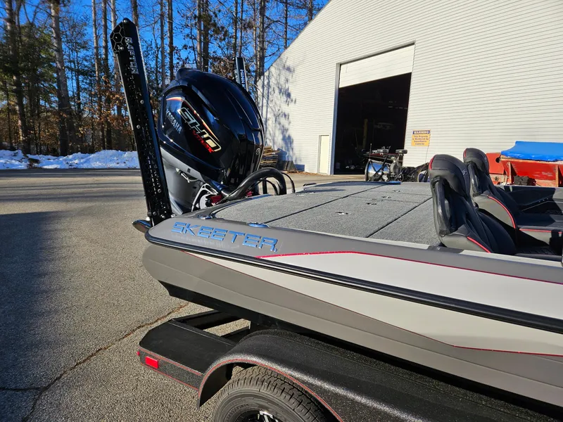 Slide: The Image of 2025 Skeeter ZXR20 boat with powerful engine, parked outdoors near a building. - 3