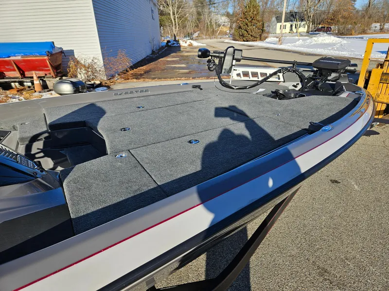Slide: The Image of 2025 Skeeter ZXR20 boat deck with fishing equipment, parked outdoors in sunlight. - 7