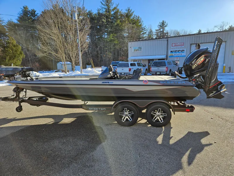 Slide: The Image of 2025 Skeeter ZXR20 boat on trailer, parked outdoors in a sunny setting. - 9