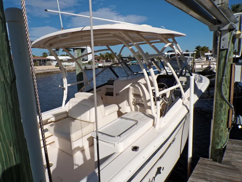 Slide: The Image of 2016 Grady-White Freedom 275 boat docked at marina under clear skies. - 13