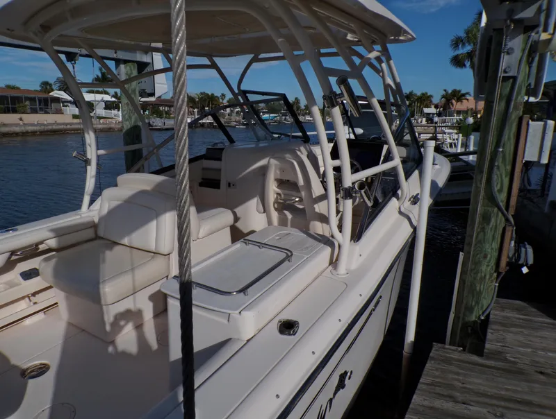 Slide: The Image of 2016 Grady-White Freedom 275 boat docked, featuring spacious seating and sleek design. - 14