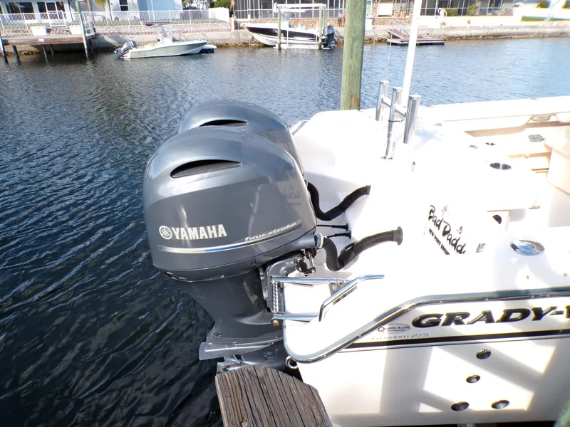 Slide: The Image of 2016 Grady-White Freedom 275 boat with twin Yamaha outboard engines docked by the water. - 15