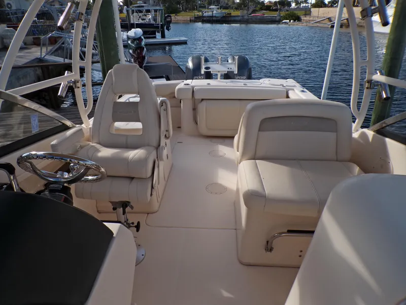 Slide: The Image of 2016 Grady-White Freedom 275 boat interior with seating, docked by the water. - 26