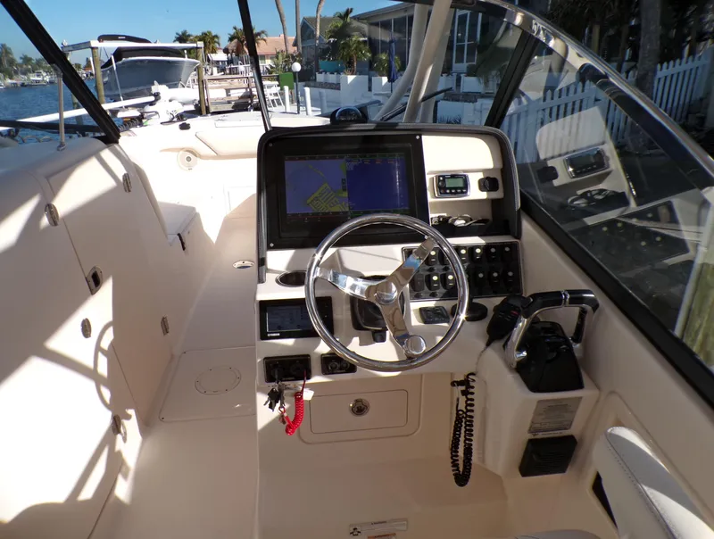 Slide: The Image of 2016 Grady-White Freedom 275 boat cockpit with steering wheel and navigation system. - 27