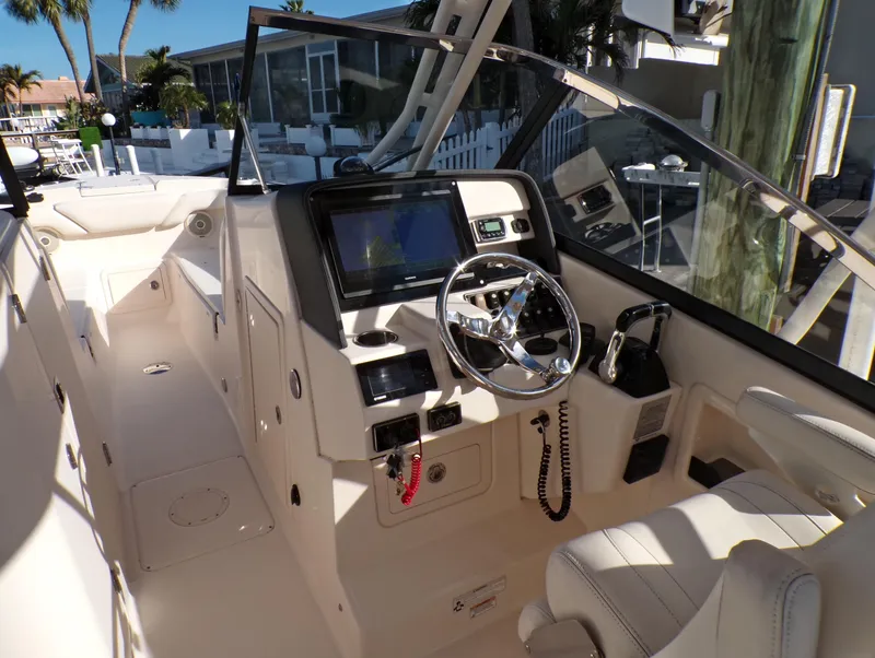 Slide: The Image of 2016 Grady-White Freedom 275 boat cockpit with steering wheel and navigation system. - 28