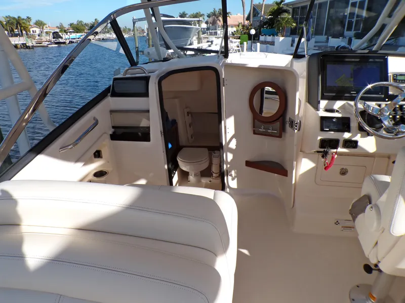 Slide: The Image of 2016 Grady-White Freedom 275 boat interior with helm, seating, and cabin view. - 35