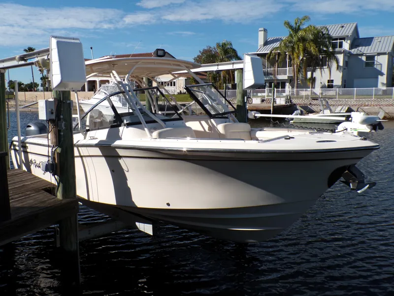 Slide: The Image of 2016 Grady-White Freedom 275 boat docked by waterfront homes under a clear sky. - 9